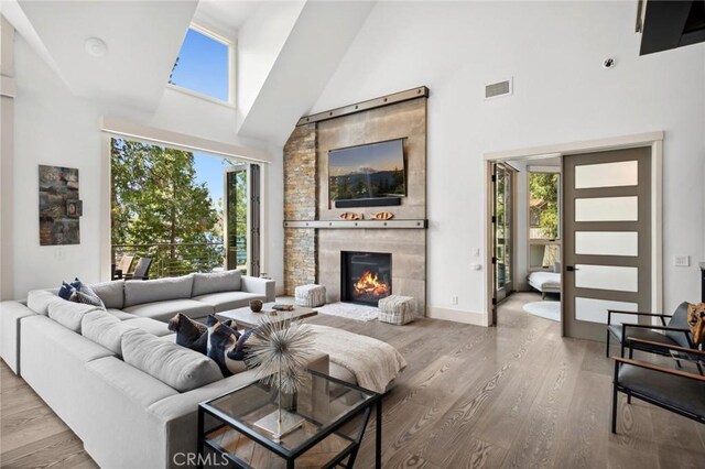 496 N State Highway 173, Lake Arrowhead, CA 92352 - living room with high vaulted ceiling, wood finished floors, and a tile fireplace