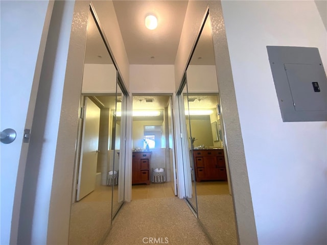 hall with light tile patterned flooring and electric panel
