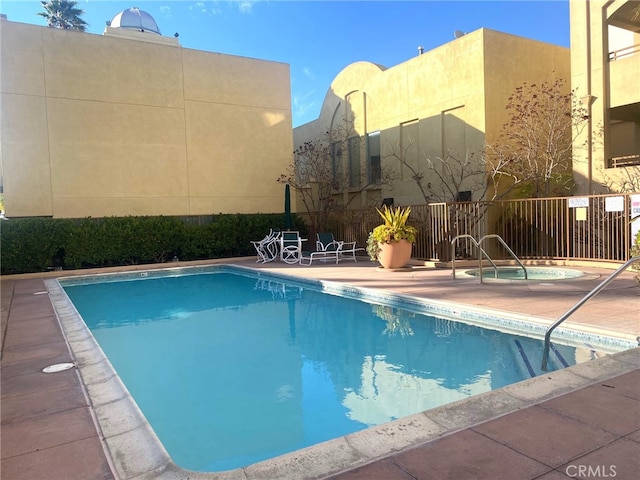community pool featuring a patio area, a community hot tub, and fence