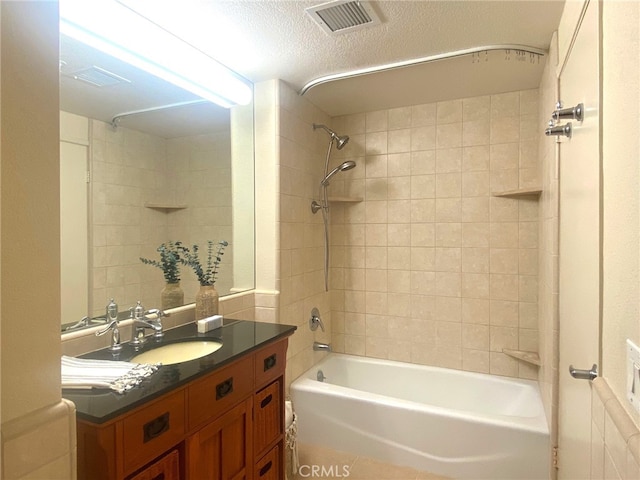 bathroom featuring visible vents, vanity, shower / washtub combination, and a textured ceiling