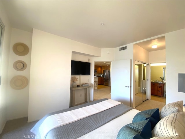 bedroom featuring light carpet, stainless steel fridge, and visible vents