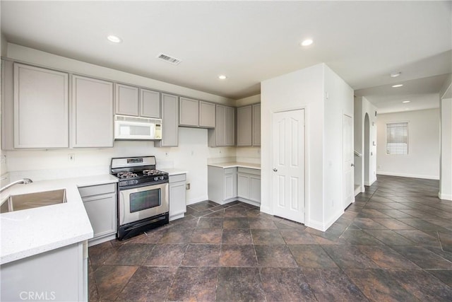 11834 Greenbluff Way, Yucaipa, CA 92399 - kitchen featuring stainless steel range with gas stovetop, white microwave, gray cabinets, recessed lighting, and dark stone finish flooring