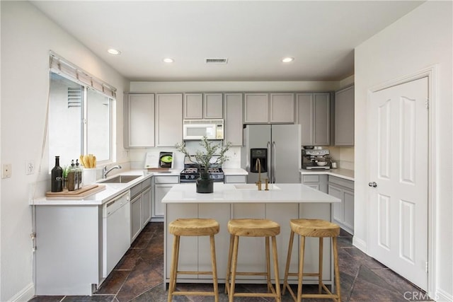 11834 Greenbluff Way, Yucaipa, CA 92399 - kitchen with white appliances, gray cabinetry, stone tile floors, a center island, and light countertops