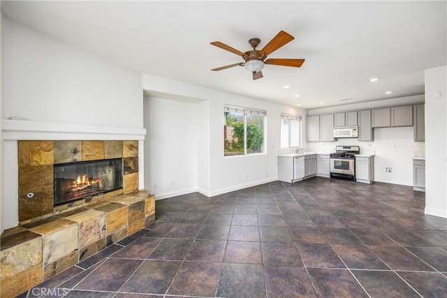 11834 Greenbluff Way, Yucaipa, CA 92399 - unfurnished living room with baseboards, ceiling fan, a tile fireplace, recessed lighting, and a sink