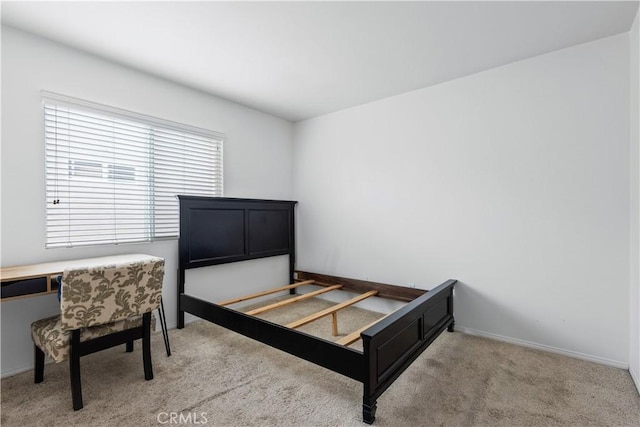 bedroom featuring light carpet and baseboards