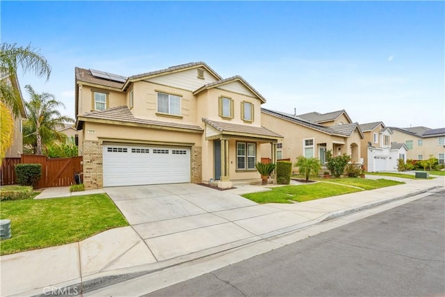traditional-style home with fence, solar panels, a garage, and stucco siding