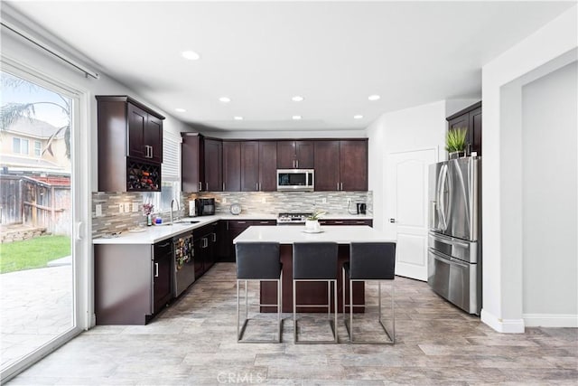kitchen with tasteful backsplash, light countertops, a center island, and appliances with stainless steel finishes
