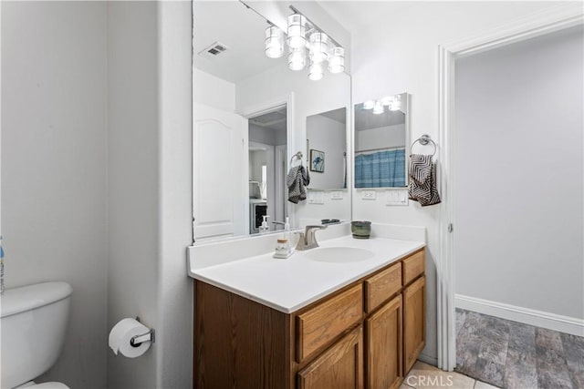 bathroom featuring toilet, wood finished floors, vanity, and visible vents