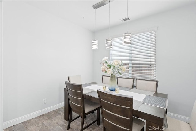 dining room with wood finished floors, baseboards, and visible vents