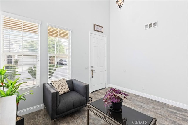 sitting room with wood finished floors, baseboards, and visible vents