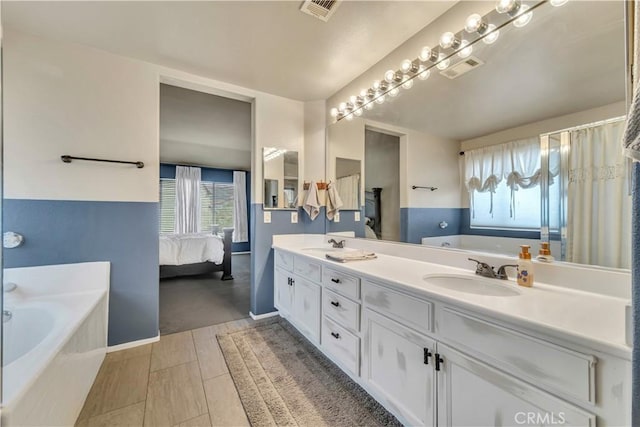 4022 Cocina Ln, Palmdale, CA 93551 - bathroom featuring a garden tub, double vanity, a sink, and a wealth of natural light