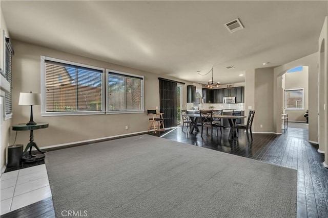 4022 Cocina Ln, Palmdale, CA 93551 - dining room featuring baseboards, a chandelier, dark wood-type flooring, visible vents, and arched walkways