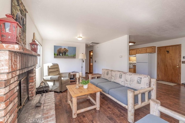 living room with wood finished floors, a fireplace, and visible vents