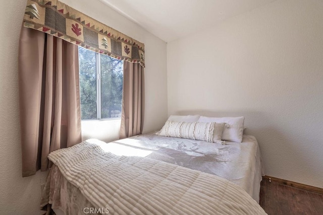 bedroom with baseboards and wood finished floors