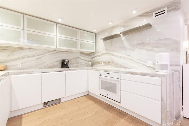 16040 W Sunset Blvd Unit 102, Pacific Palisades, CA 90272 - kitchen featuring white cabinetry, oven, visible vents, and light countertops
