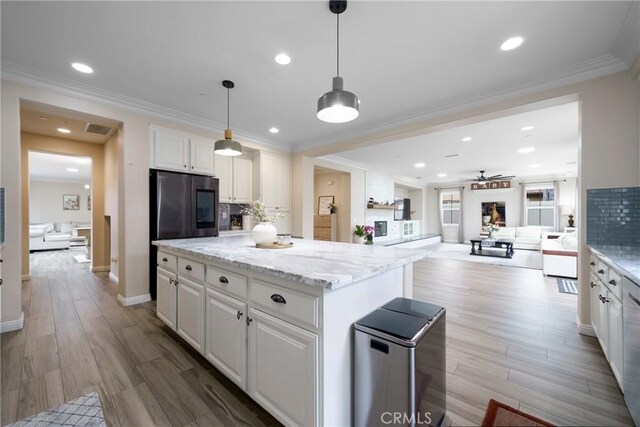 kitchen with ceiling fan, backsplash, a kitchen island, open floor plan, and white cabinetry