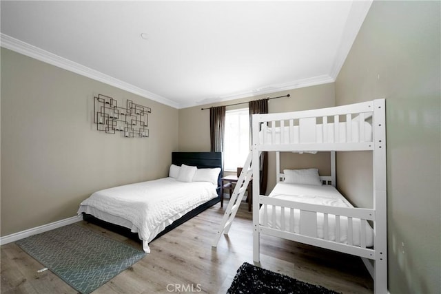 bedroom featuring wood finished floors, baseboards, and ornamental molding