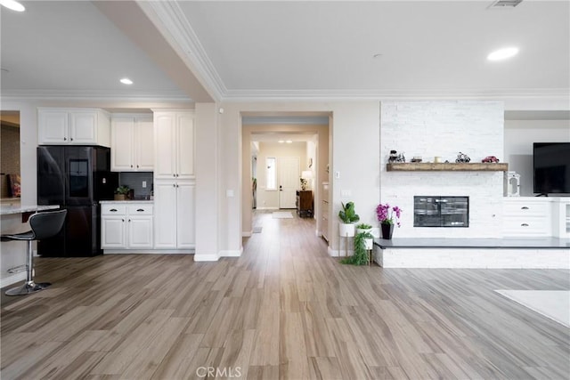1639 Tivoli St, Redlands, CA 92374 - living area featuring light wood finished floors, crown molding, a stone fireplace, and recessed lighting