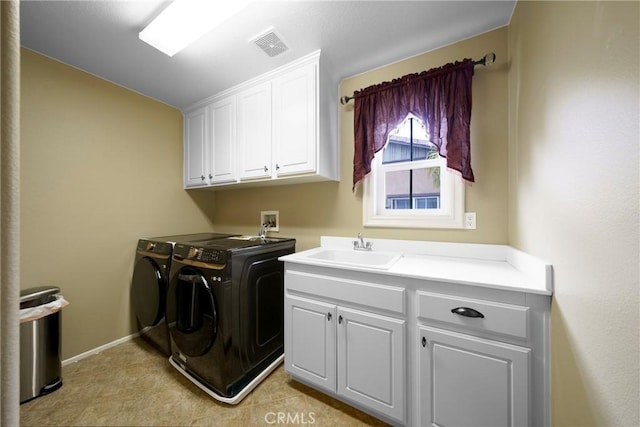 clothes washing area featuring a sink, washing machine and dryer, baseboards, visible vents, and cabinet space