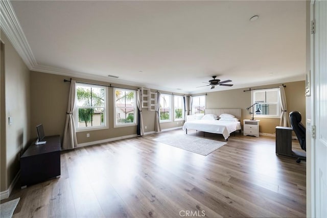bedroom featuring baseboards, crown molding, wood finished floors, and visible vents