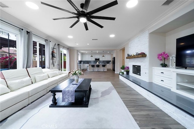 1639 Tivoli St, Redlands, CA 92374 - living area with wood finished floors, visible vents, a fireplace, crown molding, and a ceiling fan