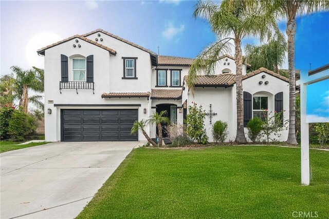 1639 Tivoli St, Redlands, CA 92374 - mediterranean / spanish house featuring a tiled roof, stucco siding, driveway, a front lawn, and an attached garage