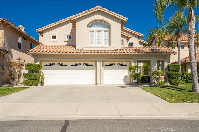 mediterranean / spanish house featuring a tile roof, an attached garage, driveway, and stucco siding