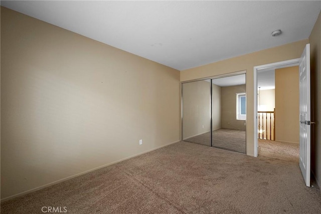 unfurnished bedroom featuring carpet, a closet, and baseboards