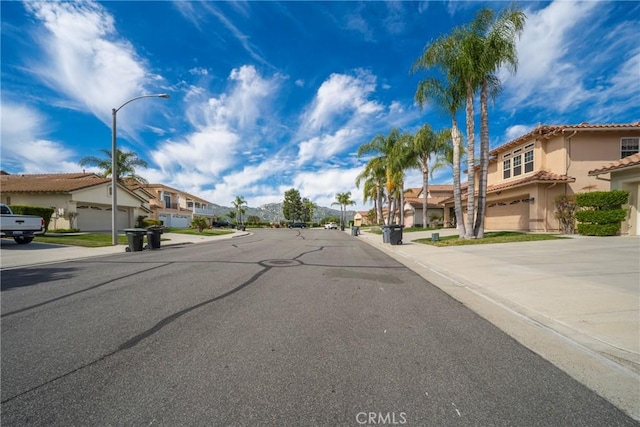 view of street with street lights, curbs, and a residential view