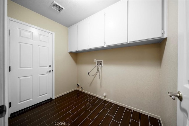 clothes washing area with visible vents, baseboards, washer hookup, dark wood-style flooring, and cabinet space