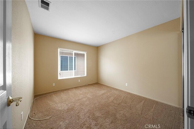 unfurnished room with visible vents, baseboards, and carpet