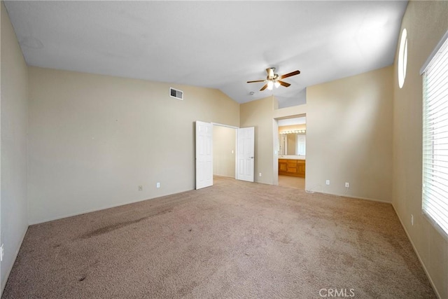 unfurnished bedroom with connected bathroom, ceiling fan, lofted ceiling, carpet flooring, and visible vents