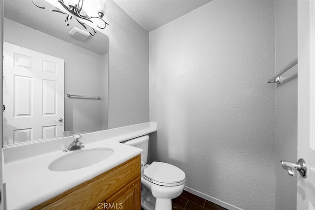 bathroom featuring visible vents, baseboards, toilet, vanity, and wood finished floors