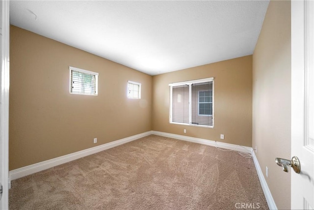 carpeted empty room with baseboards
