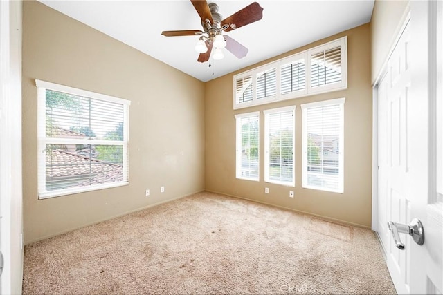 empty room with ceiling fan, carpet flooring, and baseboards