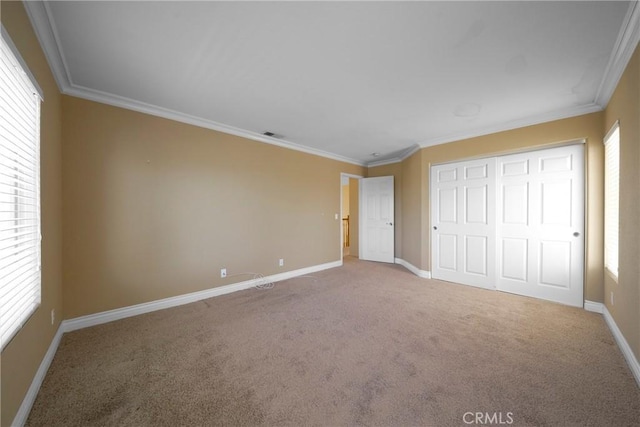unfurnished bedroom with crown molding, baseboards, and carpet flooring