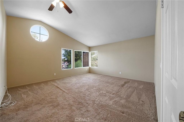 spare room featuring carpet, vaulted ceiling, a ceiling fan, and a healthy amount of sunlight