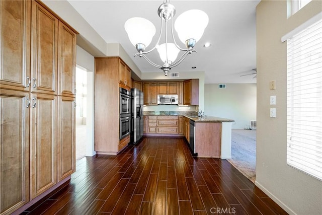 kitchen with visible vents, a sink, dark wood-style flooring, a peninsula, and stainless steel appliances