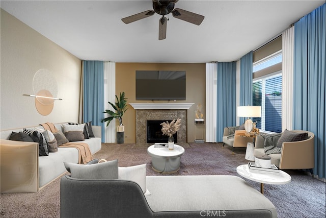 living room featuring a high end fireplace, a ceiling fan, and carpet flooring
