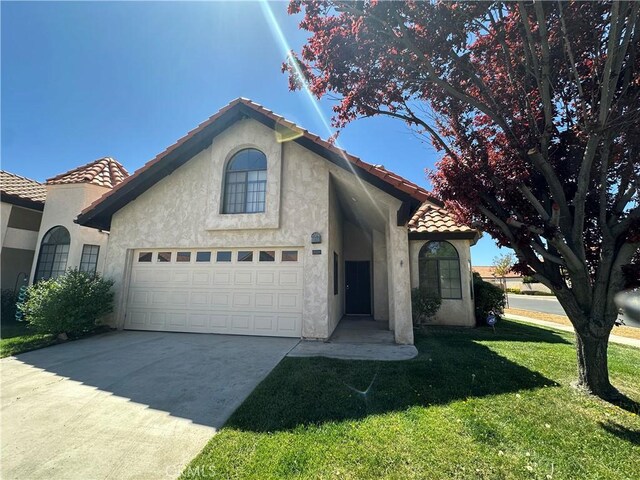 19229 Pine Way, Apple Valley, CA 92308 - mediterranean / spanish house featuring a tiled roof, stucco siding, a front lawn, concrete driveway, and an attached garage