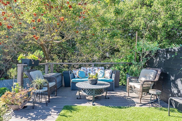 view of patio featuring outdoor lounge area, a deck, and fence