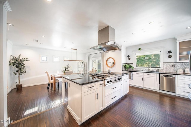 kitchen featuring a sink, dark countertops, wall chimney exhaust hood, and stainless steel appliances