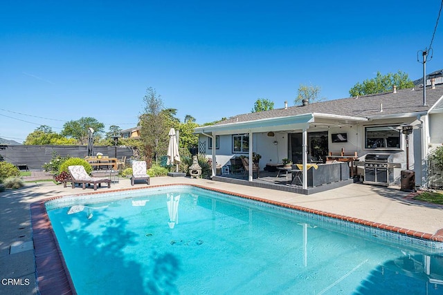 rear view of house with fence, a fenced in pool, a patio, and stucco siding