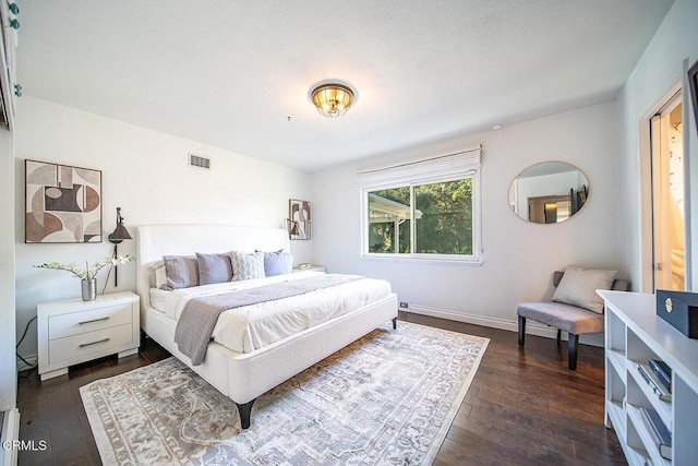bedroom with dark wood-type flooring, visible vents, and baseboards