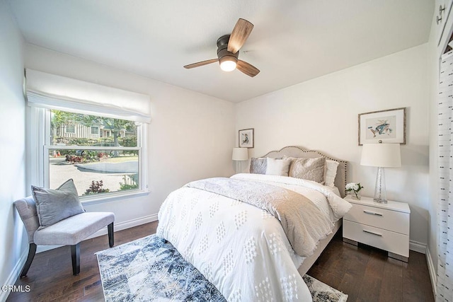 bedroom featuring dark wood-type flooring, baseboards, and ceiling fan