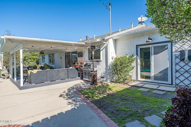 back of property featuring an outdoor living space, a patio, and stucco siding