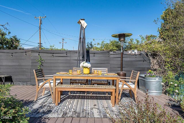 wooden deck with outdoor dining space and fence