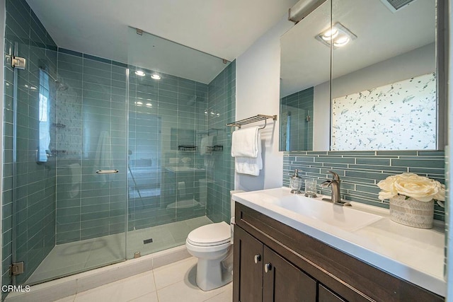 full bath with toilet, vanity, backsplash, tile patterned flooring, and a stall shower