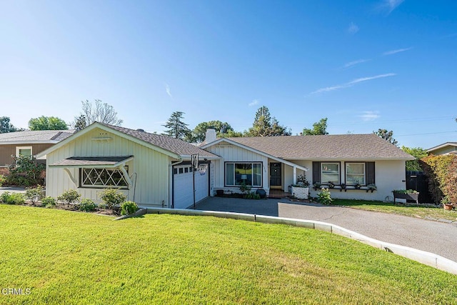 single story home with a garage, driveway, a chimney, and a front lawn