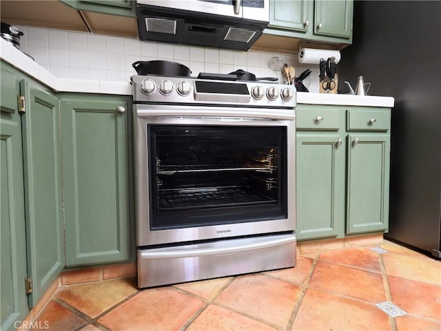 kitchen with green cabinets, appliances with stainless steel finishes, and tile countertops